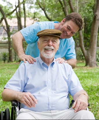 Elderly man being pushed in wheelchair