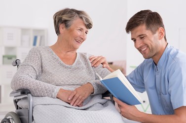 Man reading to elderly woman