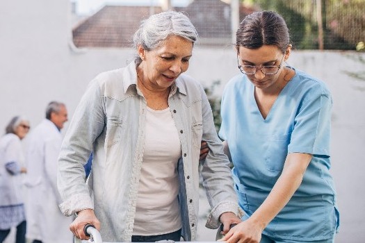 Senior woman walking with caregiver at Fellowship Square