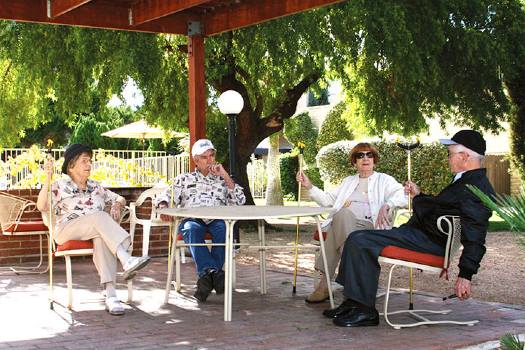 Group of seniors visiting on the patio at Fellowship Square senior living in Tucson
